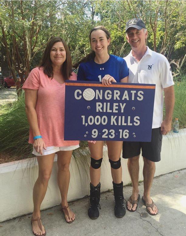 Riley Coonan (17) alongside her parents after accomplishing 1000 kills in her volleyball career