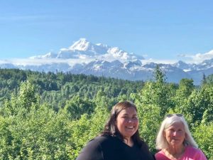 Stover and her mother stand outside of              Denali National Park, located in Alaska.    During the trip, the mother and daughter duo got to observe mama bears with their cubs, moose, caribou, and foxes with their pups.